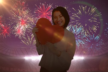 Poster - Composite image of happy woman holding heart shape paper