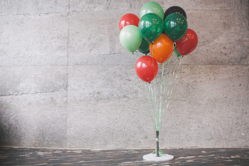 Bunch of color balloons on gray wall background.