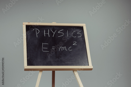 Physics word and formula E=mc2 on chalkboard Poster