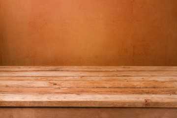 Empty wooden deck table  over brown rustic wall background for product montage display