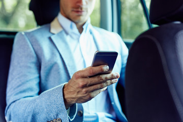 Wall Mural - man with mobile phone in hand sitting in the car