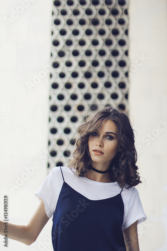 Girl In A White Shirt And A Dark Blue Dress With Short Curly Hair