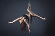 Young slim pole dance girl of asian appearаnce on a black studio background