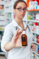 Wall Mural - Portrait of a pharmacist prescribing medicine at workplace. focus on bottle