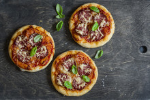 Mini Salami Pizza On A Dark Wooden Background, Top View