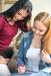 © Bojan - Two happy young female friends write something.