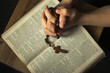 Hands praying on holy Bible