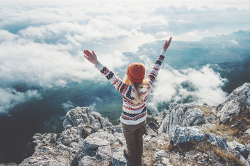 happy woman traveler on mountain summit hands raised over clouds travel lifestyle success concept ad