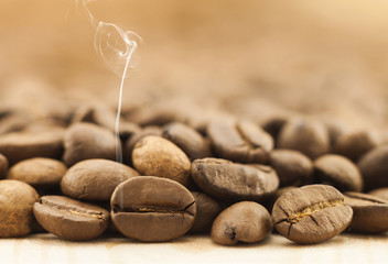 Wall Mural - Brown coffee beans with white smoke vapour on yellow textured wo