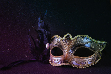 black venetian mask on glitter background