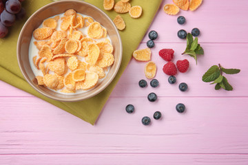 Wall Mural - Tasty cornflakes with berries on pink background