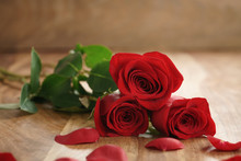 Three Red Roses And Petals On Old Wood Table With Copy Space, Romantic Background