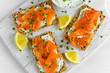 Homemade Crispbread toast with Smoked Salmon, Melted Cheese and cress salad. on white wooden board