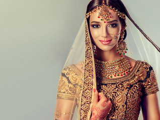 portrait of beautiful indian girl. young hindu woman model with golden kundan jewelry set . traditio