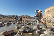 Wanderer balancieren über Steine im Fish River