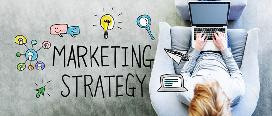 Wall Mural - marketing strategy text with man using a laptop