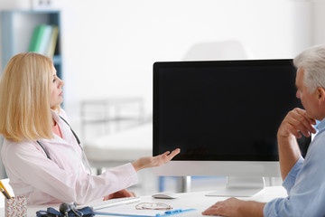 Wall Mural - Doctor showing analysis result to aged man