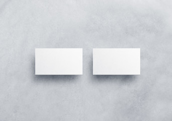 Blank white business card mockups isolated on grey textured background. Front and back side namecard design mock up presentation. Empty horizontal visiting paper sheets template with shadows.