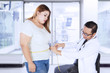 © Creativa Images - Male doctor examines an obese woman in hospital