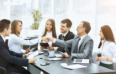 Business meeting at the table and handshake of  partners