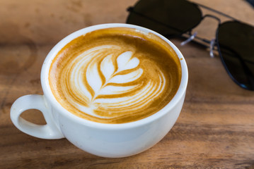 Wall Mural - cup of latte coffee on wood table