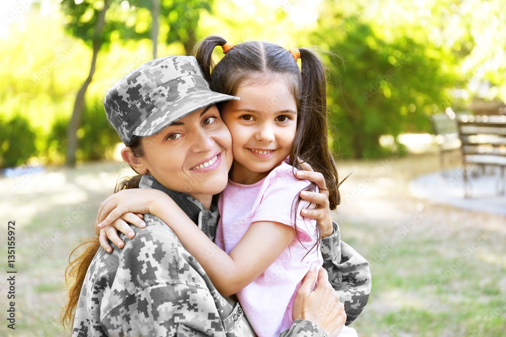 Woman in army uniform and her daughter in park