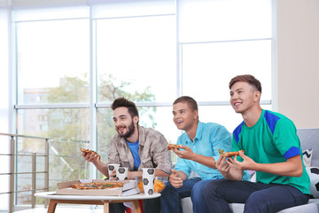 Wall Mural - Soccer fans with pizza watching game in the room