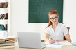 © Africa Studio - Young teacher at desk in classroom