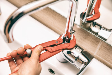 Person tightening the tap with alligator wrench