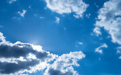 Wall Mural - sun behind clouds with blue sky