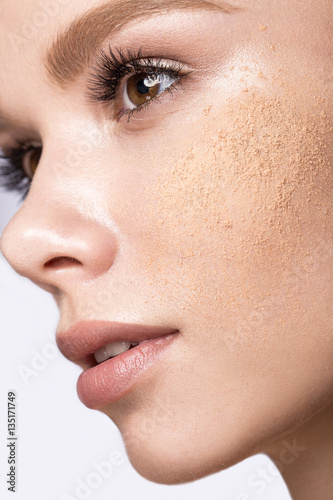 Foto Beautiful young girl with tone powder on the skin