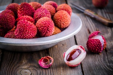 Wall Mural - Fresh organic lychee fruit in a bowl on wooden background