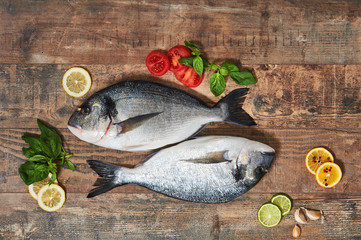 Two fresh uncooked dorado on wooden table.