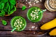 Green smoothie with spinach, banana and oatmeal on a wooden background. top view