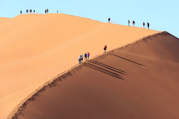 People Climbing a dune in Sossusvlei Namibia