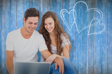 Poster - Composite image of young couple sitting on floor using laptop