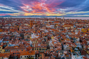 Wall Mural - Aerial view of Venice, Italy, at sunset with rooftops of buildings and vivid colors in winter afternoon.