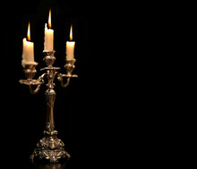 Burning Old Candle Vintage Silver Bronze Candlestick. Isolated Black Background.