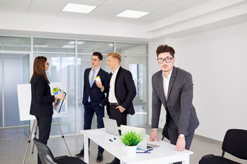 Wall Mural - Businessman with glasses on the background of business people in a modern office.