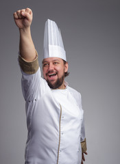 Bearded cook cap joyfully yells and pulls his hand forward