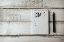 Goals Concept. Notebook With Goals List Tea On Wooden Table. Motivation 