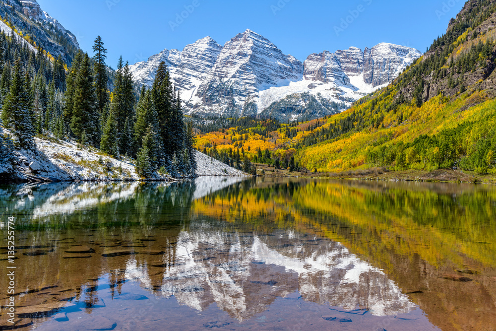 Maroon Bells and Maroon Lake - A wide-angle autumn midday view of snow coated Maroon Bells reflecting in crystal clear Maroon Lake, Aspen, Colorado, USA. - obrazy, fototapety, plakaty 