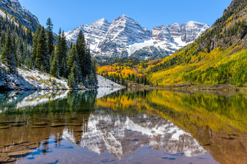 maroon bells and maroon lake - a wide-angle autumn midday view of snow coated maroon bells reflectin