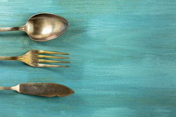 Wall Mural - Vintage fork, knife, and spoon, on turquoise with copyspace