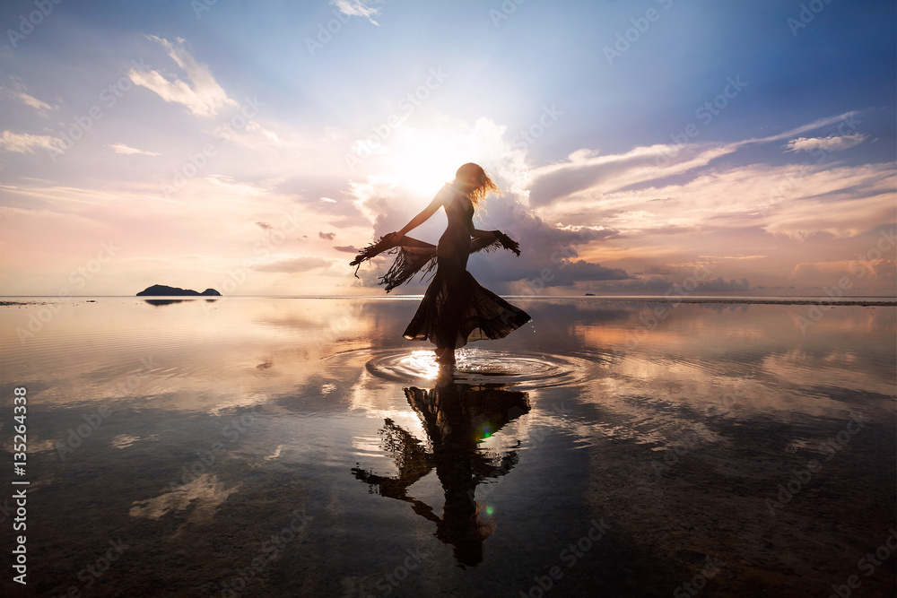 Elegant woman dancing on water. Sunset and silhouette. - obrazy, fototapety, plakaty 