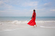 © zolotareva_elina - beautiful young woman in red dress walking on the beach