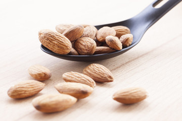 Almonds isolated on a white background, or on a plain wooden table.