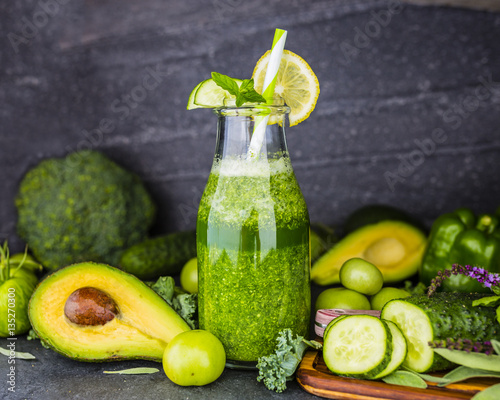Zdjęcie XXL Zdrowy zielony smoothie w szklanej butelce na zmroku kamienia tle. Jedzenie wegetariańskie i dieta detoksykacyjna.