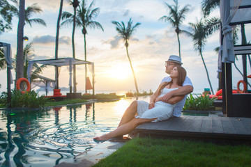 Couple on the pool at tropical resort travel concept