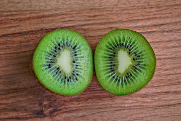 Closeup of two kiwi halves on a wooden table